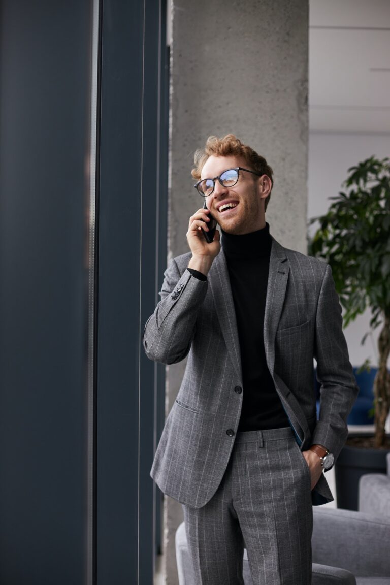 Handsome entrepreneur developer negotiating new actions of business project with investors on phone